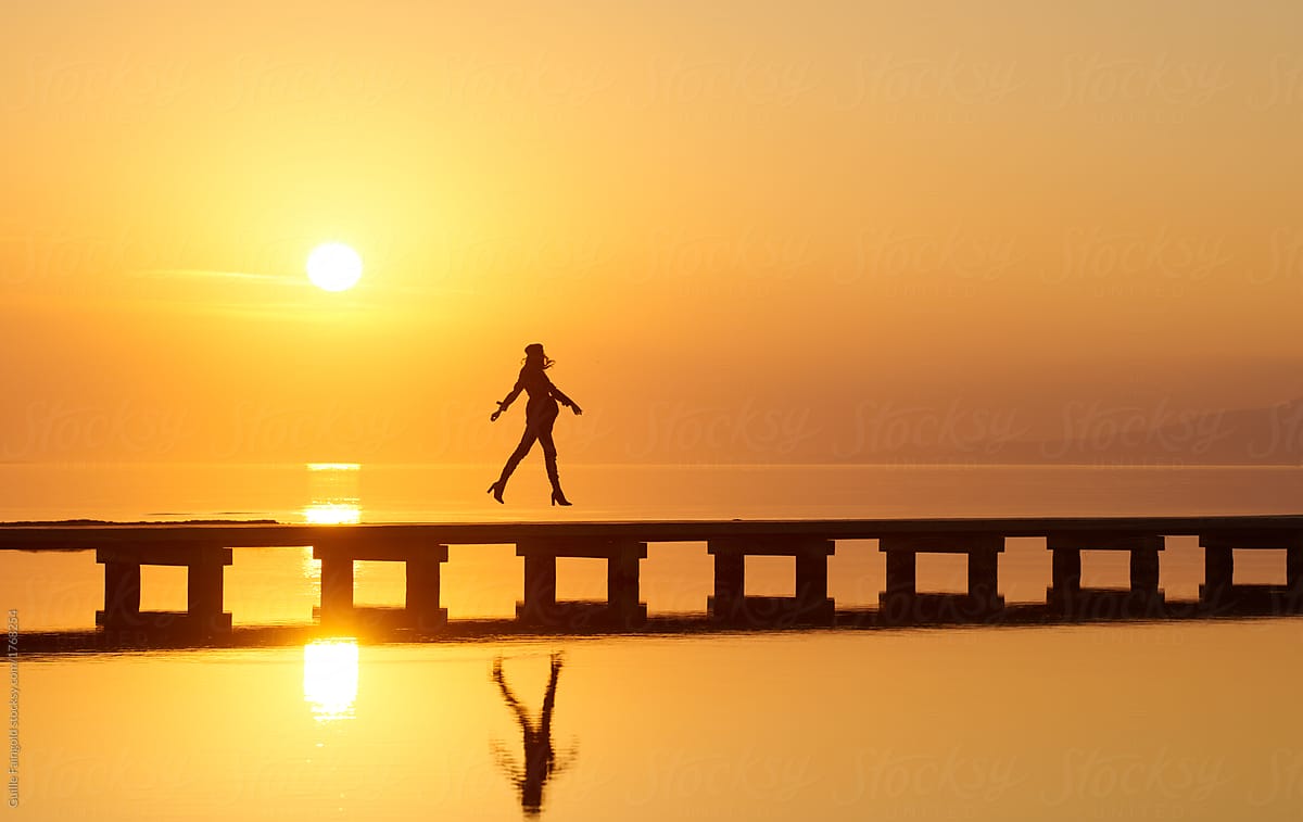 woman leaping on pier 