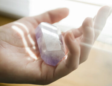 White woman holding a crystal in her hand